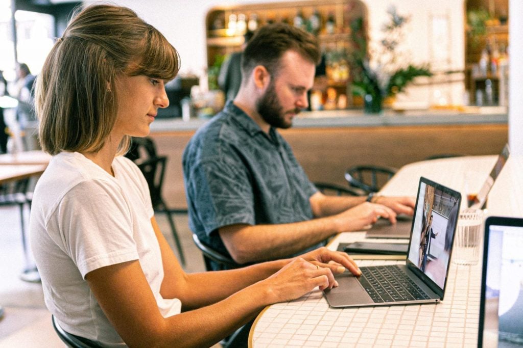 man and woman on laptops at virtual event