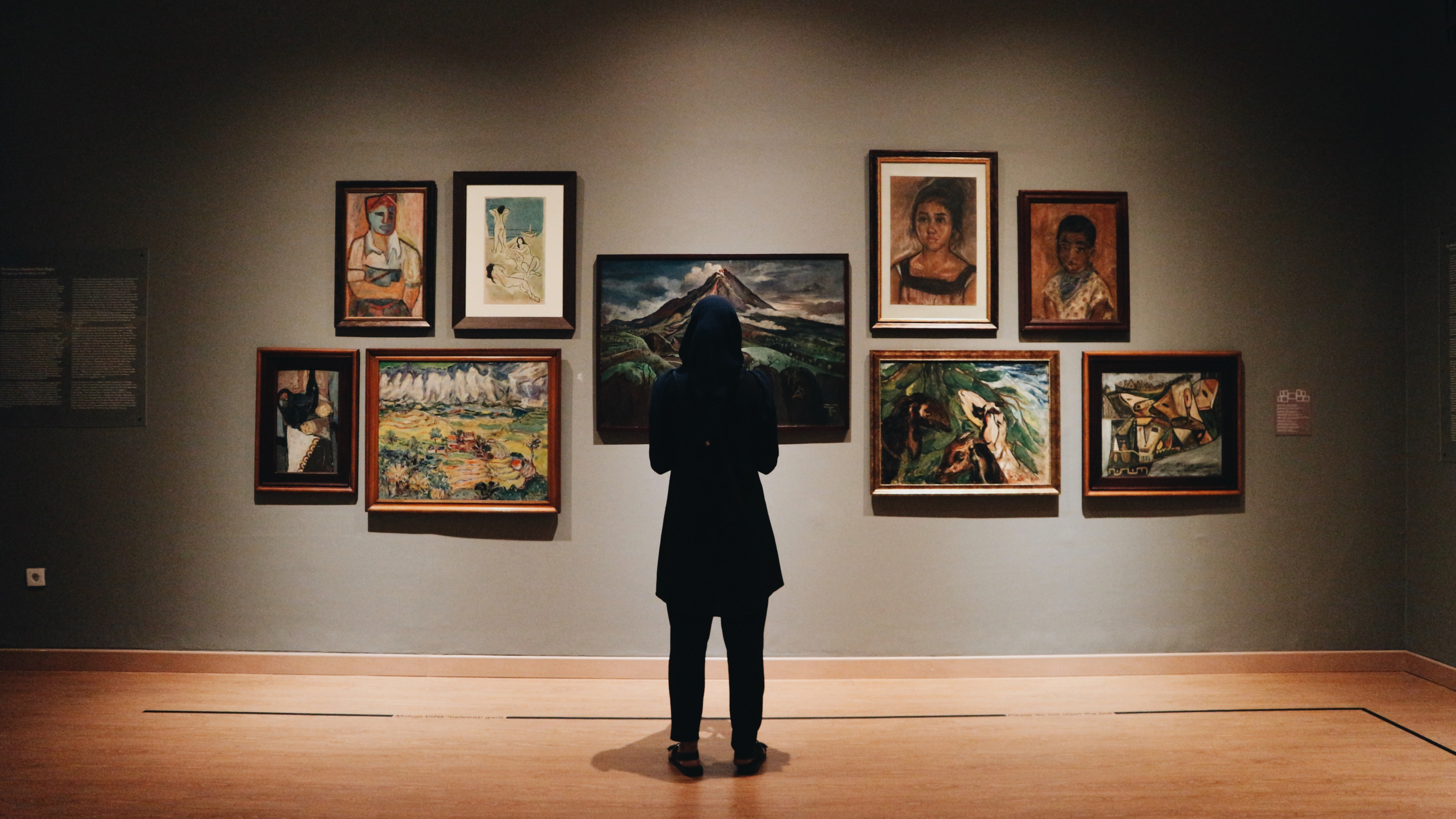 person standing looking at art in a gallery